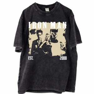 May include: A white ceramic mug with a black handle and the text "But First, Coffee" in a handwritten style. The mug is on a white surface. The mug is approximately 10 cm tall.