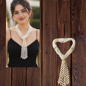 May include: A multi-strand pearl necklace featuring a woven design that transitions into a cascading, grid-like tassel of white pearls. The necklace is labeled N-01 and is shown both on a person and as a standalone piece against a wood background.