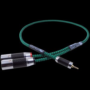 May include: A black and green audio cable with a 3.5mm jack and two RCA connectors. The cable has a braided green and black pattern. The connectors are silver and black with the brand name "MILIAN ACOUSTICS" printed on the cable.
