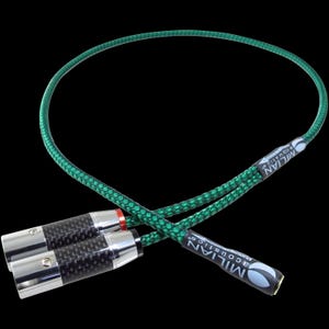 Può includere: Cavi audio con un cavo intrecciato verde e connettori in fibra di carbonio. I connettori sono argentati e neri, con dettagli rossi e dorati. I cavi riportano la scritta "MILIAN Acoustics".