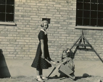 Instantané vintage - « Homestead Sisters » - petite fille jouant à l'extérieur, brouette, vieille photo trouvée, vie de ferme dans un ranch - 24