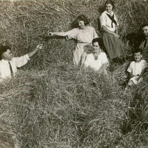 Może przedstawiać: Czarno-białe zdjęcie grupy osób siedzących i leżących na polu wysokiej trawy. Osoby ubrane są w jasne ubrania. Zdjęcie wydaje się być zrobione na początku lub w połowie XX wieku.