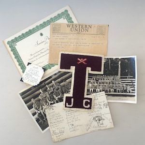 May include: A vintage Western Union telegram, a framed certificate, a black and white photo of a group of people, a maroon felt letter T with a baseball bat and ball design, and a piece of paper with handwritten names and signatures.