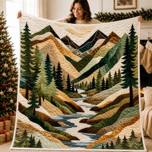 May include: A quilted throw blanket featuring a landscape scene of mountains, a winding river, and evergreen trees in shades of green, brown, tan, and cream. The fabric has a stitched texture throughout, depicting a forest valley with a flowing stream.