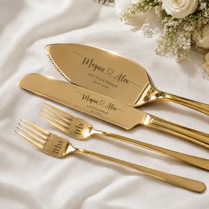 May include: A gold-toned cake serving set consisting of a serrated cake server, a knife, and two forks. The server and knife are engraved with the names Megan and Alex, a heart icon, the text ANY YOUR PHRASE, and the date 08-07-2024. The forks are engraved with Mr. and Mrs.