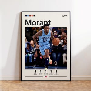 May include: A framed poster featuring a basketball player in a light blue jersey dribbling a basketball. The poster includes the name "Morant" and the year "1999". Below the image are statistics about the player.