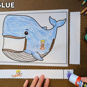 May include: A blue whale coloring page with a small figure inside, along with cut-out pieces and a glue stick. The text "3. GLUE" is at the top left. Crayons and scissors are in the background.