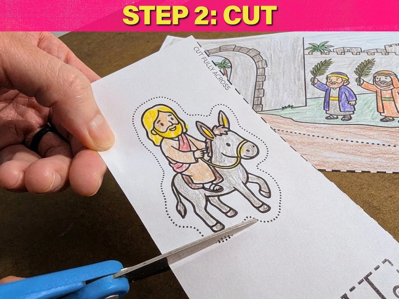May include: A coloring page with a cartoon illustration of a person riding a donkey, being cut with blue scissors. The text "STEP 2: CUT" is in a pink banner at the top. The image is part of a larger scene.