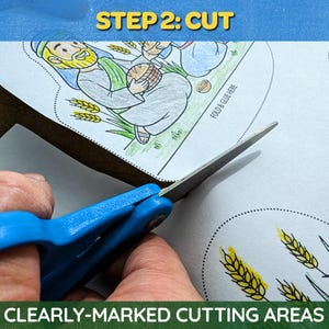 May include: Scissors with blue handles cutting a paper with a cartoon illustration. The paper has the text "STEP 2: CUT" and "CLEARLY-MARKED CUTTING AREAS". The illustration depicts figures and wheat. The paper has dotted lines for cutting.