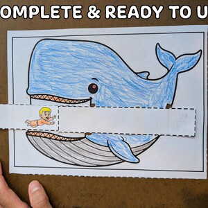 May include: A blue whale coloring page with a cut-out section and a small illustration of a person. The text "7. COMPLETE & READY TO USE" is at the top. The whale is colored in blue, with a gray underbelly and a smiling face.