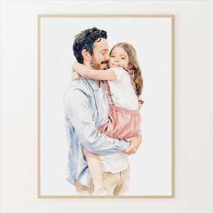 May include: Watercolor portrait of a father and child embracing. The father, with dark hair and a light blue shirt, holds the child, who wears a white top and pink overalls. The artwork is framed in a light wood tone.