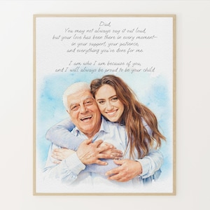 May include: A framed watercolor print featuring a smiling father and daughter embracing. The print includes a handwritten message to a father, with a blue watercolor wash background. The frame is a light brown color.