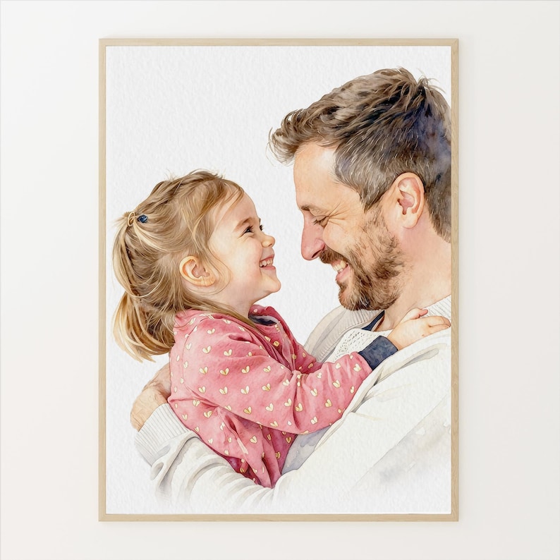 May include: Watercolor portrait of a father and daughter embracing and smiling at each other. The daughter wears a pink jacket with heart-shaped patterns. The father is wearing a white sweater. The artwork is framed in a light wood frame.