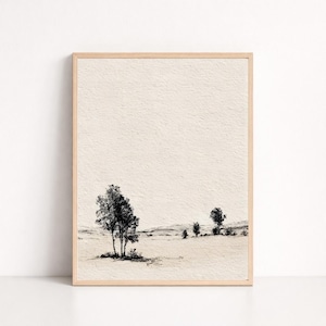 May include: A framed black and white landscape art print. The artwork depicts a minimalist scene of several trees and rolling hills. The print is set against a textured, off-white background, and framed in a light wood.