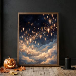 May include: A framed art print depicts a night sky filled with floating candles above fluffy clouds. The artwork has a warm color palette with shades of orange, yellow, and blue. A carved pumpkin and a black candle sit on a wooden surface.