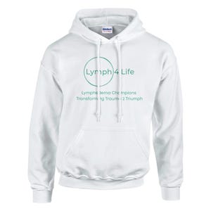 Könnte beinhalten: Weißer Kapuzenpullover mit dem Text "Lymph 4 Life" in einem grünen Kreis, mit den Worten "Lymphedema Champions Transforming Trauma 2 Triumph" darunter. Der Pullover hat eine Vordertasche und Kordelzüge.