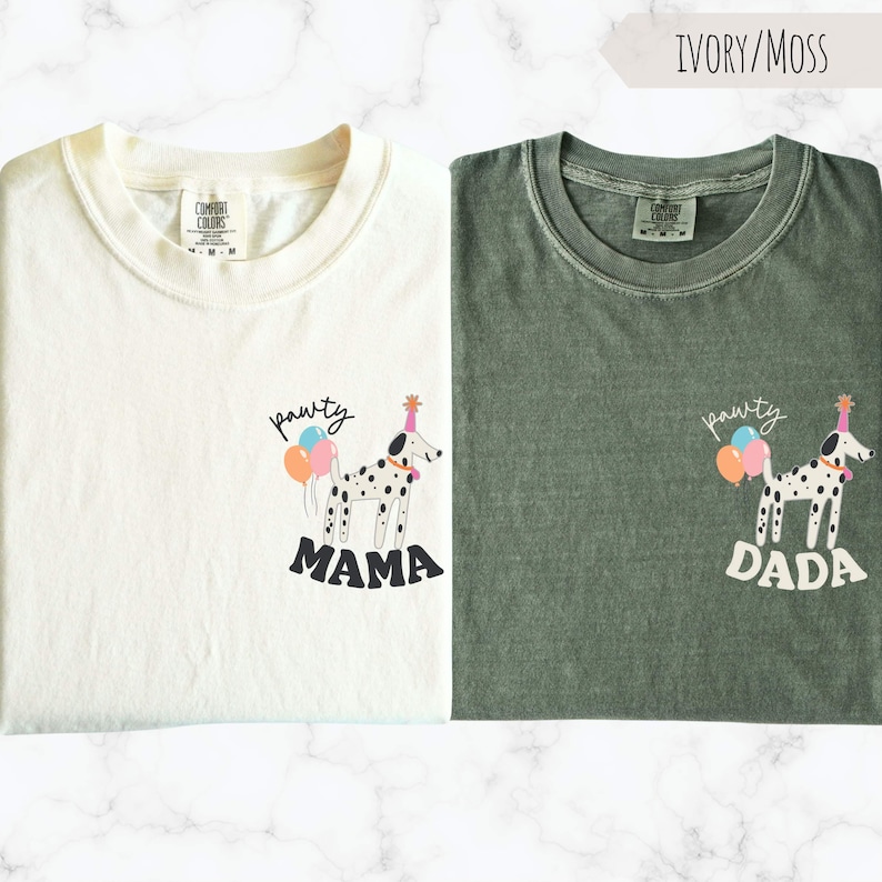 May include: Two t-shirts, one ivory and one moss green, each featuring a Dalmatian dog illustration with a party hat and balloons. The ivory shirt says "Mama" and the green shirt says "Dada" below the dog.