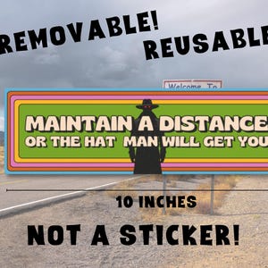 The bumper magnet is floating above an abandoned desert highway. The dimensions of the magnet and other info is included. The bumper magnet is 10x3 inches, removable, reusable, and not a sticker.