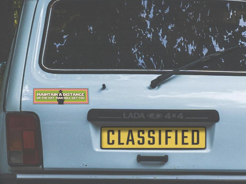 A 1990s station wagon with the magnet on the bumper. The license plate reads "classified."