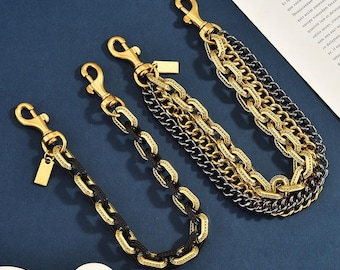 May include: Three metal chains featuring a mix of gold and black links. Each chain is equipped with a gold-toned lobster clasp at one end and a small rectangular metal tag. The chains vary in thickness and link design, showcasing a layered appearance.