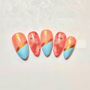 Uñas postizas de verano con diseño playero: purpurina floral en coral, azul cielo y dorado.