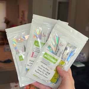 May include: Three white, resealable pouches with holographic accents, each containing Herbalife Nutrition tea concentrate packets and drink mix sticks. Labels on the pouches list flavors including Ocean Water, Lemon-Lime Liftoff, and Raspberry & Coconut.