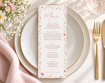 May include: A vertical rectangular menu card featuring a delicate floral border with pink and yellow wildflowers. The text includes sections for Appetizers, Main Course, Sides, Desserts, and Drinks, with the bottom text reading Sophie's Baby Shower 12.15.26.