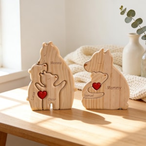 Op de afbeelding: Houten berenbeeldjes voor het gezin met een hartvormig accent. E&eacute;n beeldje heeft de namen "Lucas" en "Oscar", de andere "Samuel" en "Mommy". De beren zijn lichtbruin en staan op een houten tafel.