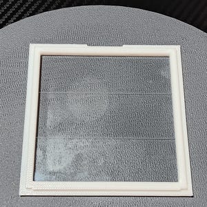 the lid, upside down showing the rear notch(to assist with opening), and the front angle(to help keep it closed)