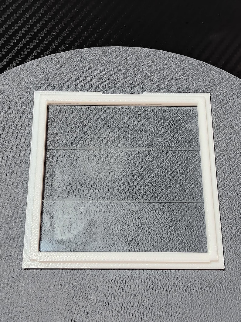 the lid, upside down showing the rear notch(to assist with opening), and the front angle(to help keep it closed)