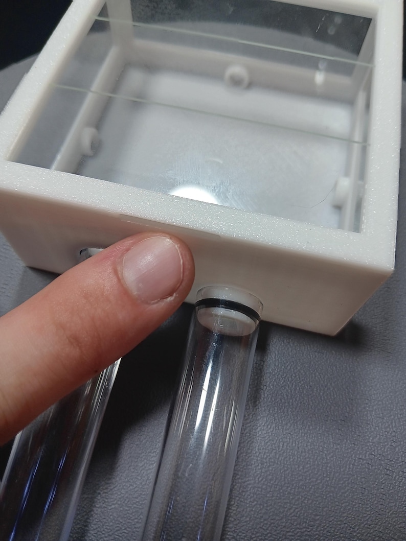 my finger pointing at the rear notch of the lid which is used to open it.