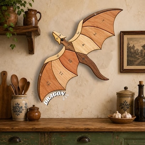 May include: A wall-mounted wooden dragon-shaped clock featuring segmented wings crafted from various shades of natural wood. The clock face displays numbers one through twelve integrated into the wing sections, with the word DRAGON printed in white near the bottom edge.