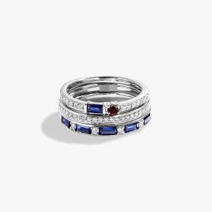 Puede incluir: Una pila de tres anillos de plata. El anillo superior tiene una pequeña gema roja redonda. El anillo del medio tiene una fila de pequeñas gemas azules rectangulares. El anillo inferior tiene gemas azules y blancas.