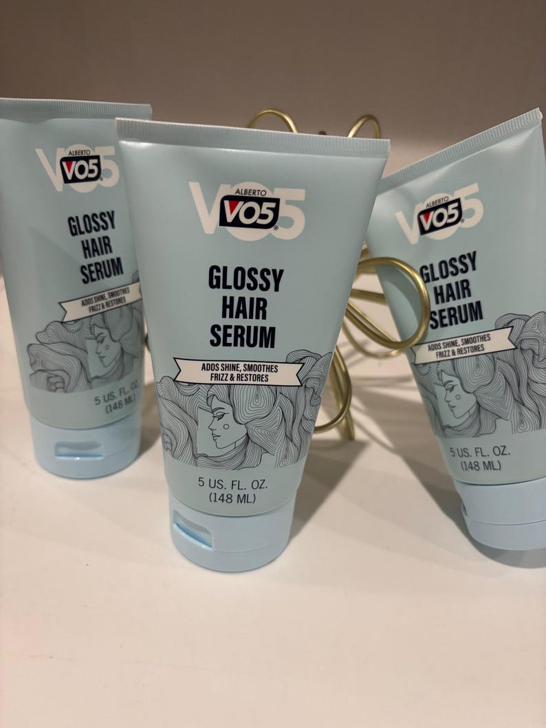 May include: Several tubes of VO5 Glossy Hair Serum are displayed. The light blue tubes have white text that reads "Glossy Hair Serum" and "Adds Shine, Smooths Frizz & Restores." Each tube contains 5 US fl. oz. (148 mL) of product.