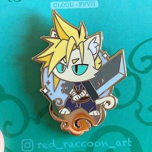 Peut inclure: Épingle en émail dorée représentant un personnage félin avec des cheveux jaunes hérissés et une grande épée grise. Le personnage porte des vêtements bleus et noirs, sur un fond bleu clair et or. Le texte "CLOUD - FFVII" est en haut.