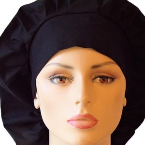 May include: A black chef hat with a gathered top and a wide band. The hat is made of a soft, comfortable fabric and is designed to be worn by both men and women.