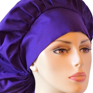 May include: A purple chef hat with a gathered top and a wide brim. The hat is made of a soft, comfortable fabric and is perfect for keeping hair out of the way while cooking.