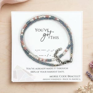 May include: A white ceramic mug with a black handle and the text "But First, Coffee" in a black, bold font. The mug is sitting on a white surface.