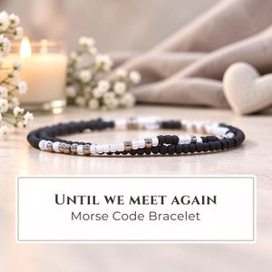 May include: A Morse code bracelet featuring a sequence of matte black, glossy white, and metallic silver beads. The text "UNTIL WE MEET AGAIN" and "Morse Code Bracelet" is printed in black on a white rectangular label below the jewelry.