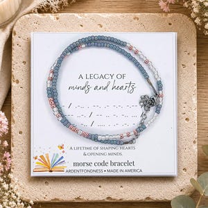 May include: A Morse code bracelet featuring small blue, pink, and clear beads on a display card. The card reads A LEGACY OF minds and hearts, A LIFETIME OF SHAPING HEARTS & OPENING MINDS, morse code bracelet, ARDENTFONDNESS, and MADE IN AMERICA.