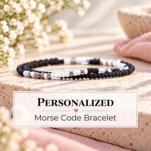May include: A bracelet featuring a pattern of matte black beads, glossy white beads, and metallic silver-tone spacers arranged in a Morse code sequence. The image includes text that reads: PERSONALIZED Morse Code Bracelet.