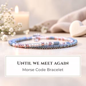 May include: A Morse code bracelet featuring a repeating pattern of small, round beads in shades of dusty blue, metallic silver, and rose gold. The text "UNTIL WE MEET AGAIN" and "Morse Code Bracelet" is printed in black on a white rectangular label.