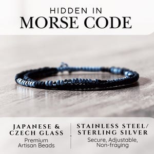 May include: A beaded bracelet featuring matte black and light blue glass beads with metallic silver accents. The text HIDDEN IN MORSE CODE, JAPANESE & CZECH GLASS, STAINLESS STEEL/STERLING SILVER, Premium Artisan Beads, Secure, Adjustable, Non-fraying is visible.