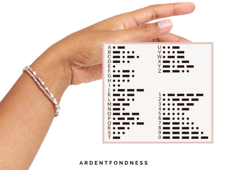 Peut inclure: Un bracelet &agrave; deux rangs avec des perles roses et blanches est port&eacute; au poignet. Une carte affiche le code Morse pour l'alphabet et les chiffres. Le texte "ARDENTFONDNESS" est en bas de l'image.