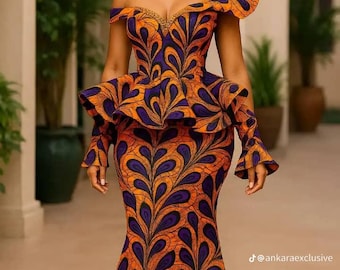 May include: An off-the-shoulder, floor-length gown in orange and purple. The dress features a unique pattern and a ruffled peplum. The design includes a large shoulder accent. The text "@ankaraexclusive" is visible.