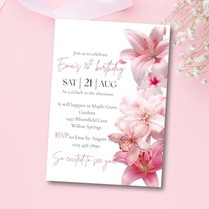 May include: A white invitation card with pink text and floral accents. The card reads "Ema's 1st birthday" with the date, time, and location details. Pink lilies and other flowers decorate the right side of the card.