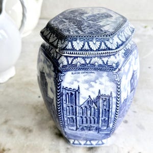 May include: A blue and white ceramic jar with a hexagonal shape and a lid. The jar features a detailed illustration of Ripon Cathedral, with the words "RIPON CATHEDRAL" printed on the front.