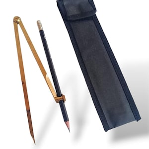 May include: A brass proportional divider, a pencil, and a black fabric case. The divider features two adjustable arms and a pencil holder. The pencil is black with a sharpened tip. The case is rectangular with a flap.
