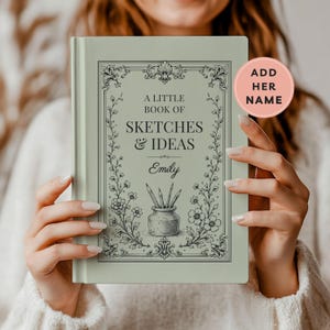 May include: A sage green hardcover book with the text A LITTLE BOOK OF SKETCHES & IDEAS and the name Emily printed on the front cover. The cover features a decorative border with floral vines and an illustration of pencils in a jar.