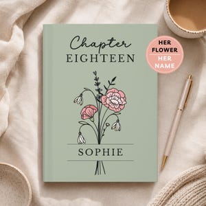 May include: A sage green hardcover book featuring the text "Chapter EIGHTEEN" and "SOPHIE" in black lettering. A line drawing of a floral bouquet with pink and white flowers is centered on the cover. A pink circular sticker reads "HER FLOWER HER NAME".
